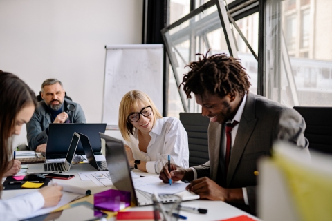 Four employees working together around a conference table